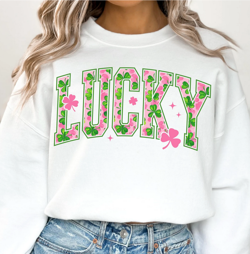 White sweatshirt with 'LUCKY' design featuring pink flowers and green leaves, worn by a person.